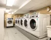 Common laundry area featuring light tile patterned flooring and washer and dryer