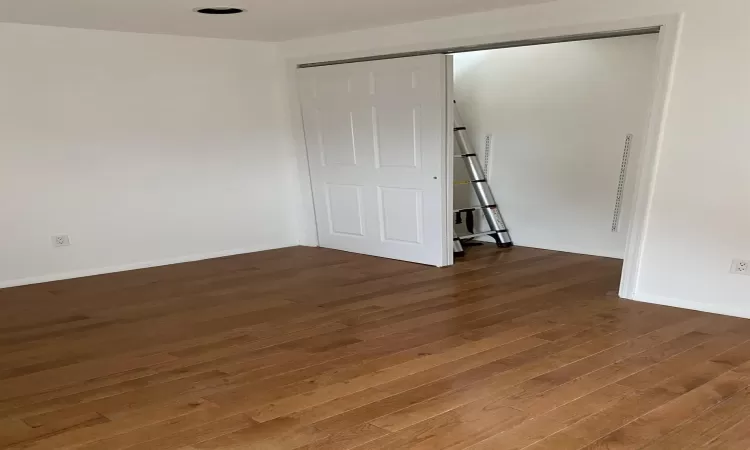 Unfurnished room with wood-type flooring and baseboards