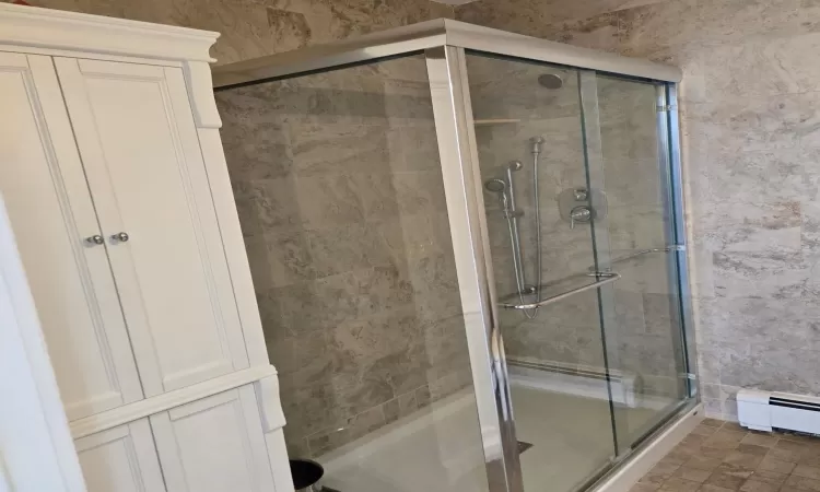 Bathroom featuring a stall shower and baseboard heating