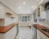 Kitchen featuring a baseboard heating unit, dishwasher, wood counters, and open shelves