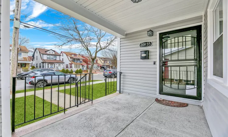 Entrance to property featuring a residential view, a porch, and a lawn