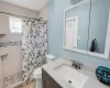 Bathroom featuring a stall shower, vanity, and toilet