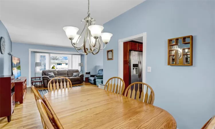 Dining area featuring light wood-style floors and a notable chandelier