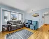 Living room featuring attic access, baseboards, vaulted ceiling, and wood finished floors