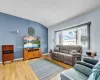 Living area featuring lofted ceiling, light wood finished floors, and baseboards