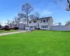 Raised ranch featuring entry steps, fence, driveway, and a front lawn