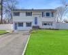 Bi-level home featuring aphalt driveway, a front lawn, fence, and a gate