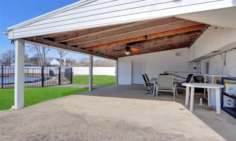 View of patio featuring outdoor dining space, fence, and a ceiling fan