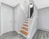 Stairs with a baseboard heating unit, baseboards, and wood finished floors