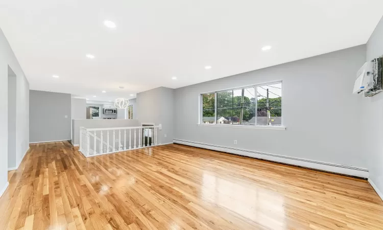 Spare room featuring light wood-type flooring, baseboards, baseboard heating, and recessed lighting