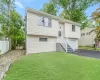 Split foyer home featuring driveway, an attached garage, fence, and a front yard