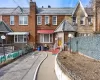 View of front of house with a high end roof, brick siding, a chimney, and fence private yard