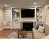 Living room with light wood-style floors, a fireplace, crown molding, and recessed lighting