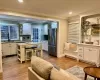 Kitchen with stainless steel fridge, light wood-style flooring, a sink, open shelves, and backsplash