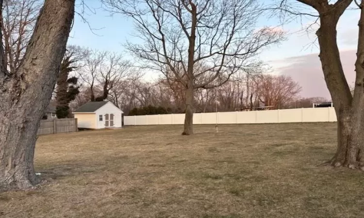 View of yard with a fenced backyard and an outdoor structure