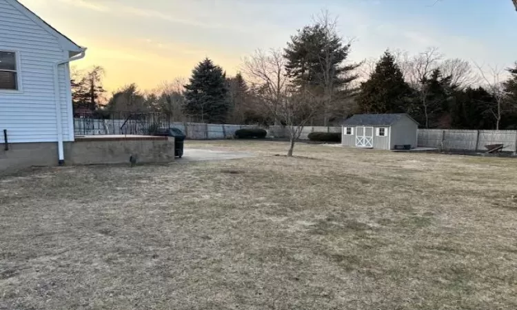 View of yard with a fenced backyard, an outdoor structure, and a storage unit