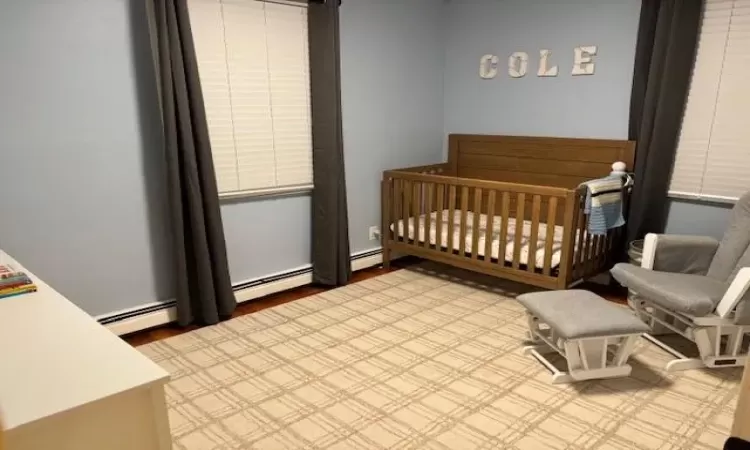 Bedroom with a nursery area and a baseboard heating unit