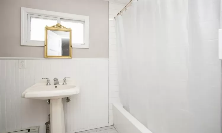 Bathroom featuring a wainscoted wall and a baseboard radiator