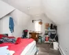 Bedroom with a baseboard heating unit, wood finished floors, and lofted ceiling