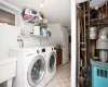 Clothes washing area featuring light tile patterned floors, laundry area, washer and clothes dryer, and a sink