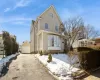 Traditional-style home featuring aphalt driveway, an outdoor structure, and a detached garage