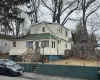 View of front of house featuring an AC wall unit and fence