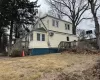 Rear view of house with a wall unit AC, a yard, and a deck