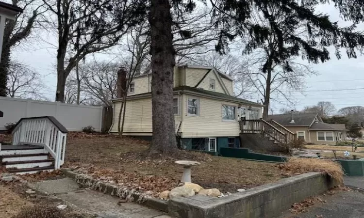 View of side of property with fence and a chimney