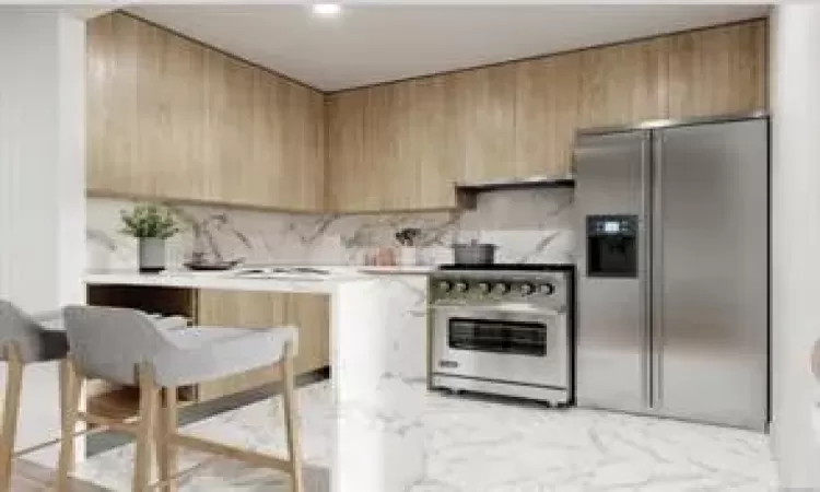 Kitchen with decorative backsplash, modern cabinets, stainless steel appliances, light countertops, and light brown cabinetry