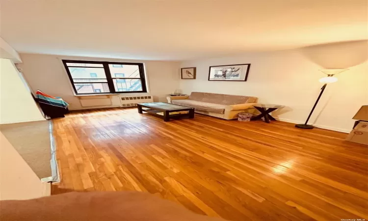 Unfurnished living room featuring radiator and light wood-style flooring