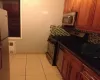 Kitchen featuring light tile patterned floors, stainless steel appliances, visible vents, and decorative backsplash