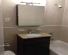 Full bath featuring tile walls, bathing tub / shower combination, tasteful backsplash, toilet, and vanity