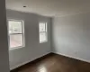 Unfurnished room with dark wood-type flooring, ornamental molding, and baseboards