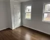 Unfurnished bedroom featuring ornamental molding, dark wood-style flooring, multiple windows, and baseboards