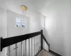 Stairway featuring a healthy amount of sunlight, an inviting chandelier, baseboards, and wood finished floors