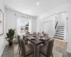 Dining room featuring a baseboard heating unit, stairway, wood finished floors, and recessed lighting