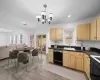 Kitchen with visible vents, dishwasher, dark countertops, light brown cabinets, and a sink