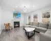 Living area featuring a chandelier, recessed lighting, a premium fireplace, and wood finished floors