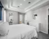 Bedroom with a tray ceiling, baseboards, visible vents, and dark colored carpet