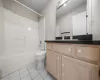 Bathroom with toilet, tile patterned flooring, vanity, and shower / bathing tub combination