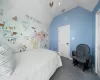 Bedroom featuring lofted ceiling, visible vents, dark carpet, and baseboards