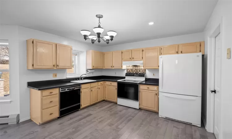 Kitchen featuring electric range oven, light brown cabinets, freestanding refrigerator, and dishwasher