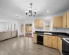 Kitchen with dark countertops, baseboard heating, light brown cabinets, a sink, and dishwasher