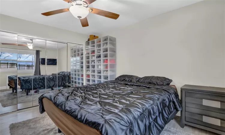 Bedroom featuring ceiling fan, a closet, and wood finished floors