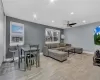 Living area with a ceiling fan, recessed lighting, baseboards, and light wood finished floors