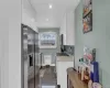 Kitchen with baseboards, white cabinets, decorative backsplash, radiator heating unit, and stainless steel appliances