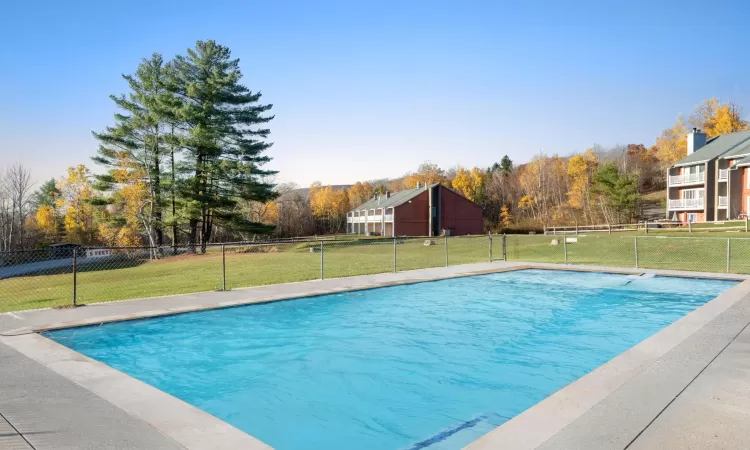 View of swimming pool with a yard, fence, and a fenced in pool