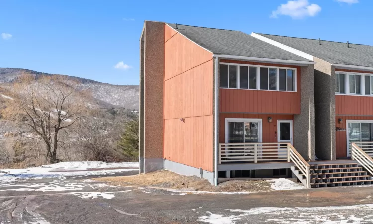 View of property featuring a shingled roof and a mountain view