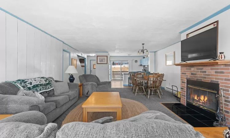 Living area featuring a baseboard heating unit and a brick fireplace