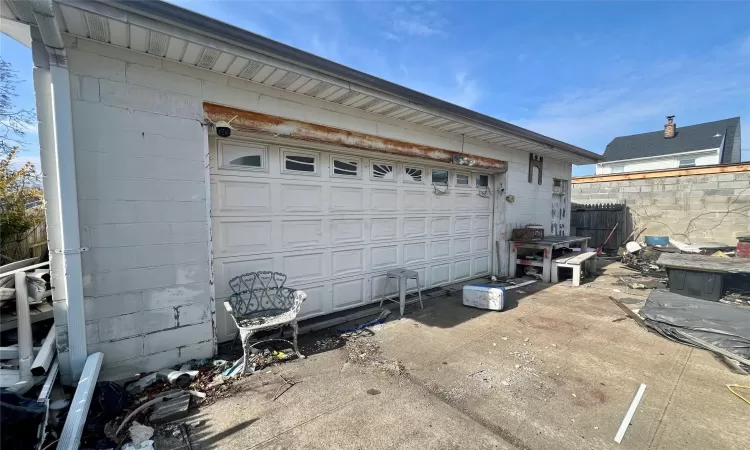 Garage featuring driveway and fence